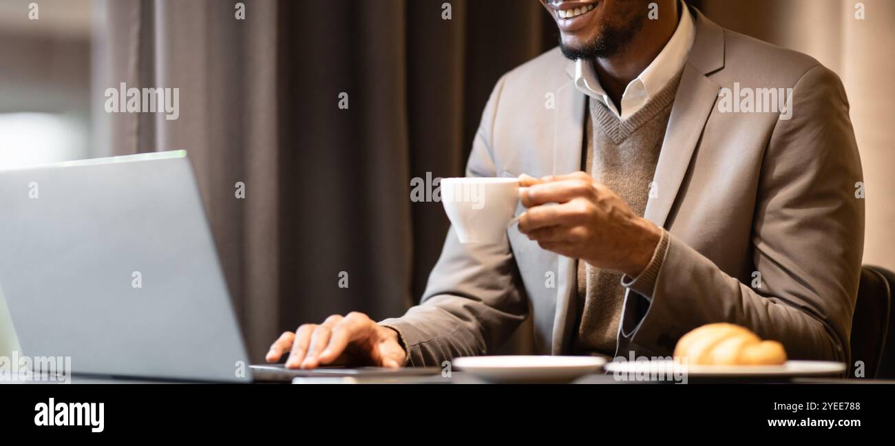 Afro manager drinking tea and using pc Stock Photo