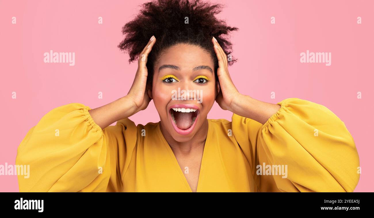 Happy afro woman screaming and grabbing her head Stock Photo