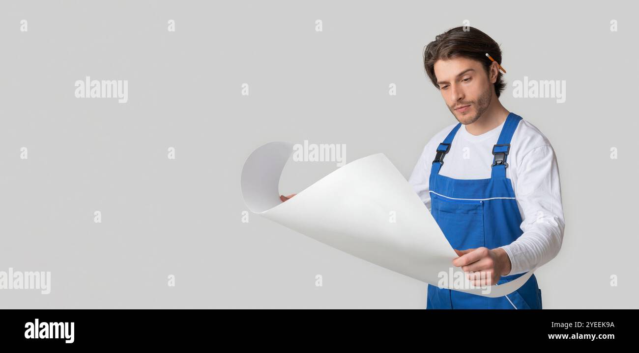 Professional Foreman Wearing Uniform Checking Construction Draft Over Light Studio Background Stock Photo