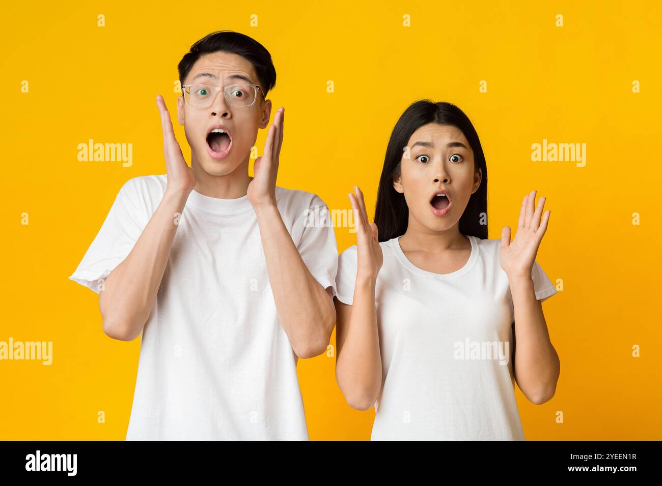 Amazed young asian couple expressing shock, yellow background Stock ...