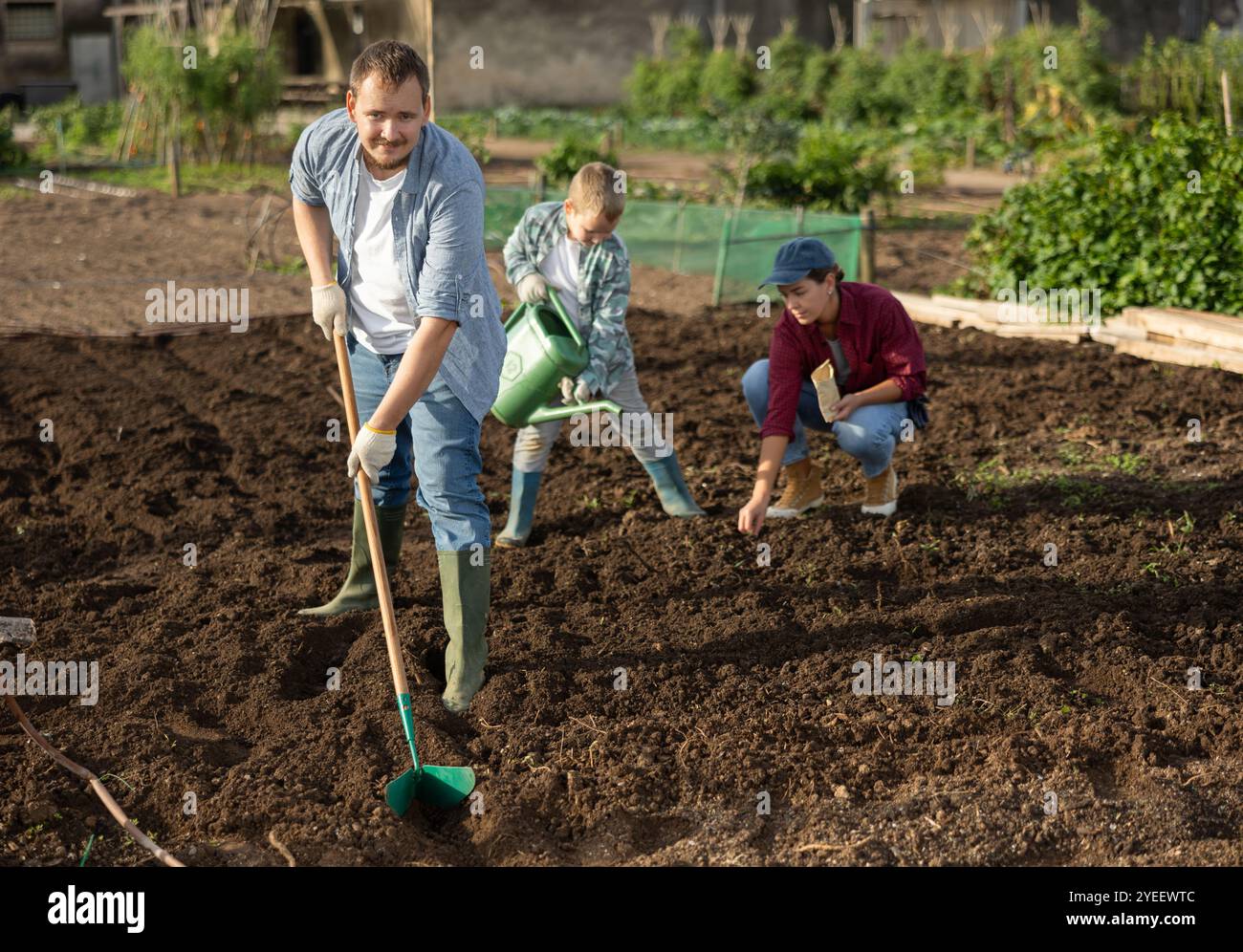Male farmer with shovel dripping garden Stock Photo - Alamy