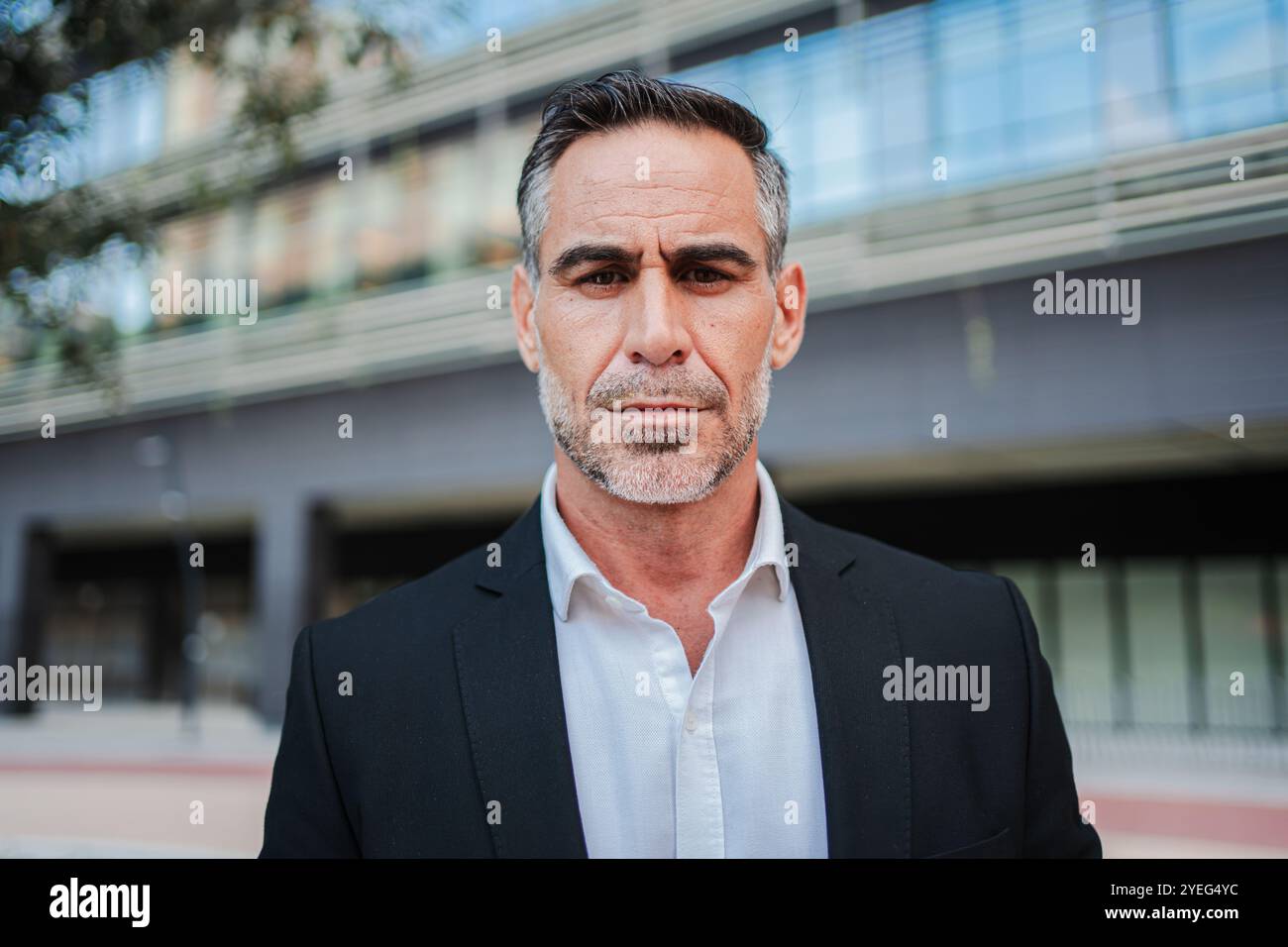 Distinguished Middle Aged Executive in Classic Black Suit Poses Confidently Outside Modern Corporate Building, Portraying Professional Mature Business Man with Authority and Seasoned Experience. High quality photo Stock Photo