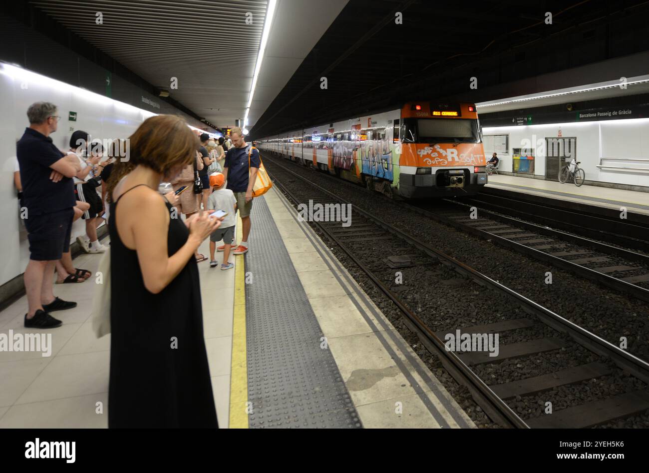 Passengers waiting for the train on the platform at the Passeig de Gràcia train station in Barcelona, Spain. Stock Photo