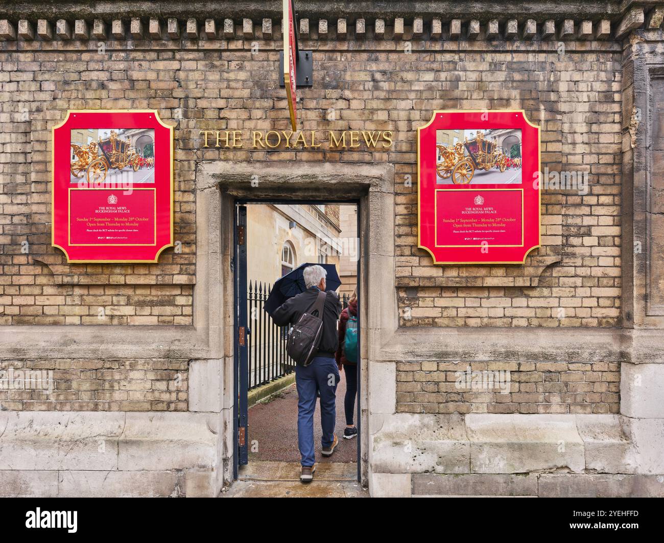 Visitors walk through the door to The Royal Mews, Buckingham Palace, London, England. Stock Photo