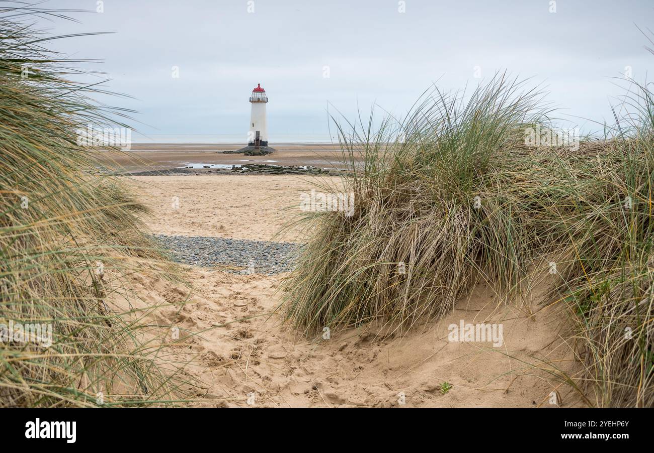 Sand dunes and marram grass frame Talacre Lighthouse at low tide on the