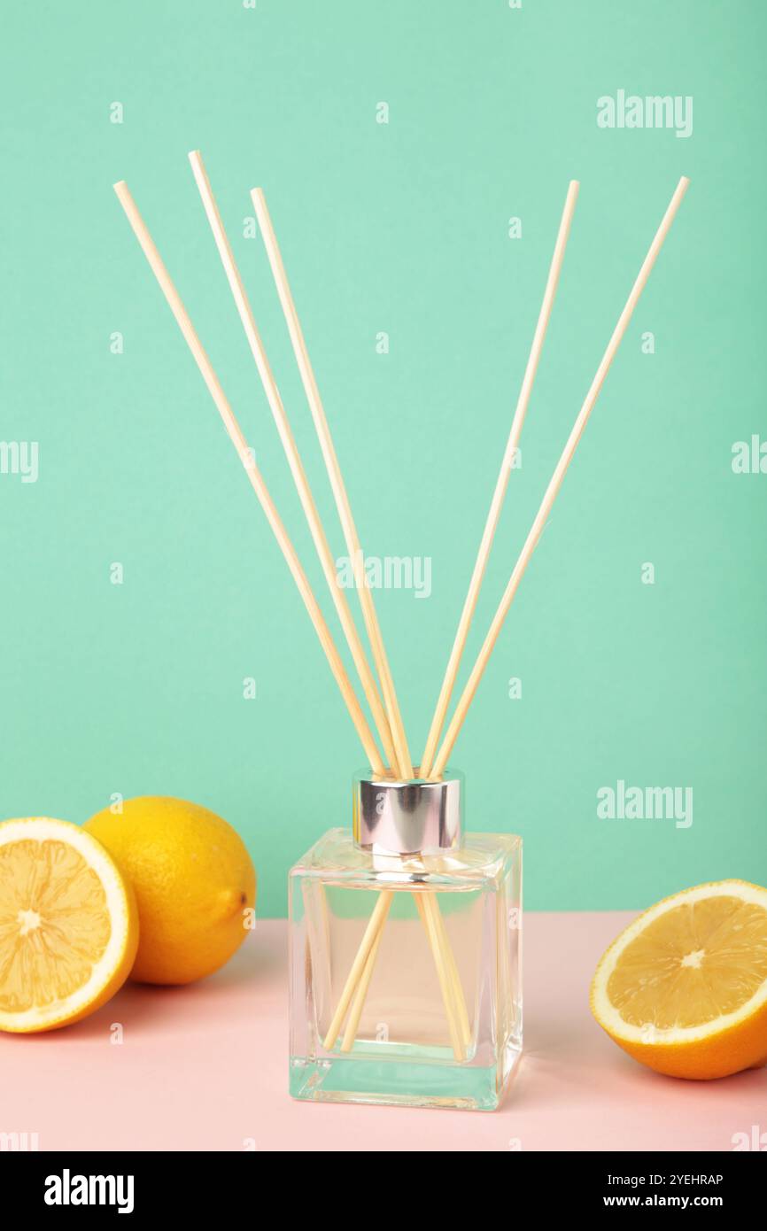 Reed diffuser and lemons on mint background. Top view Stock Photo