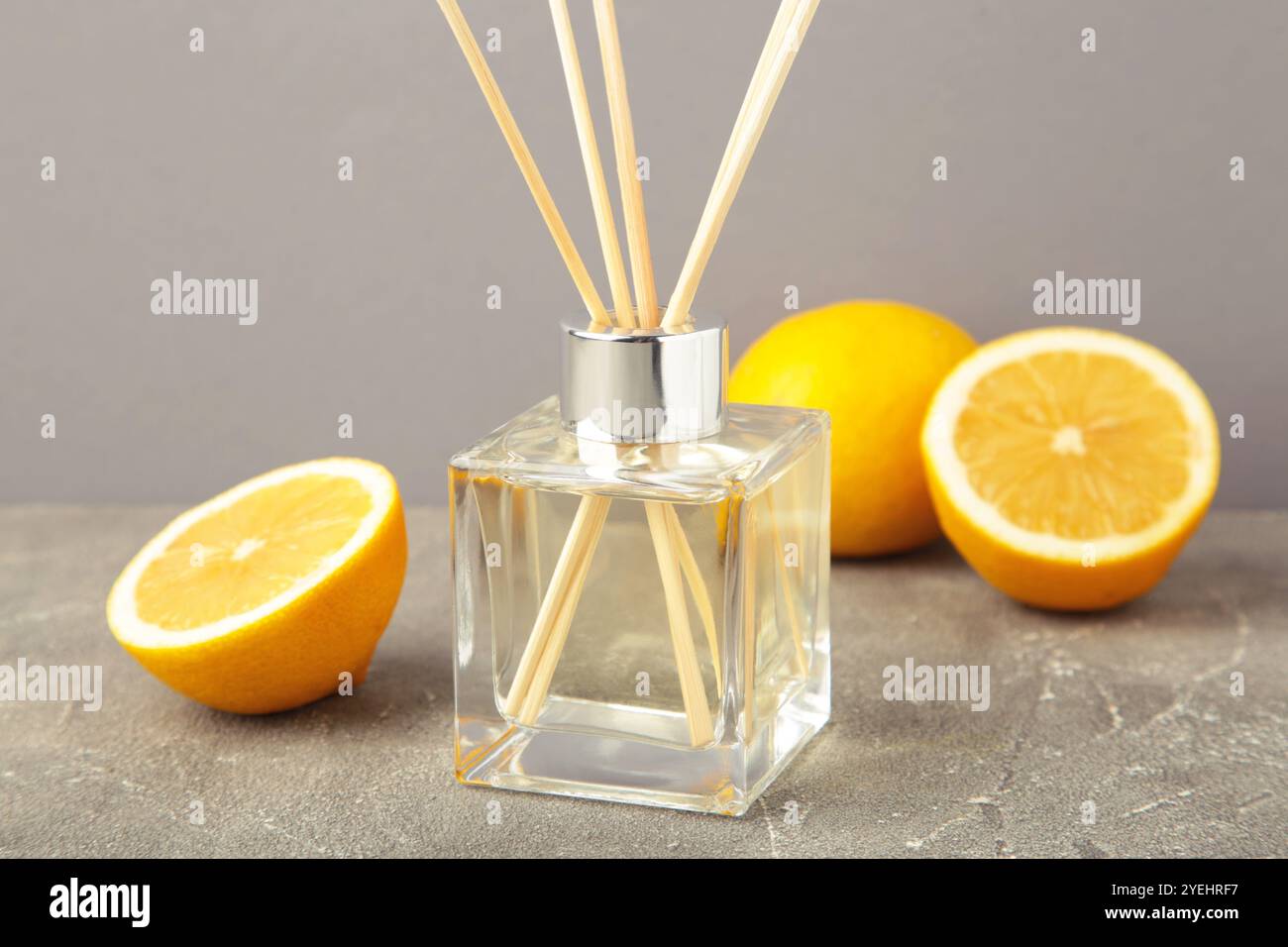 Reed diffuser and lemons on grey concrete background. Top view Stock Photo