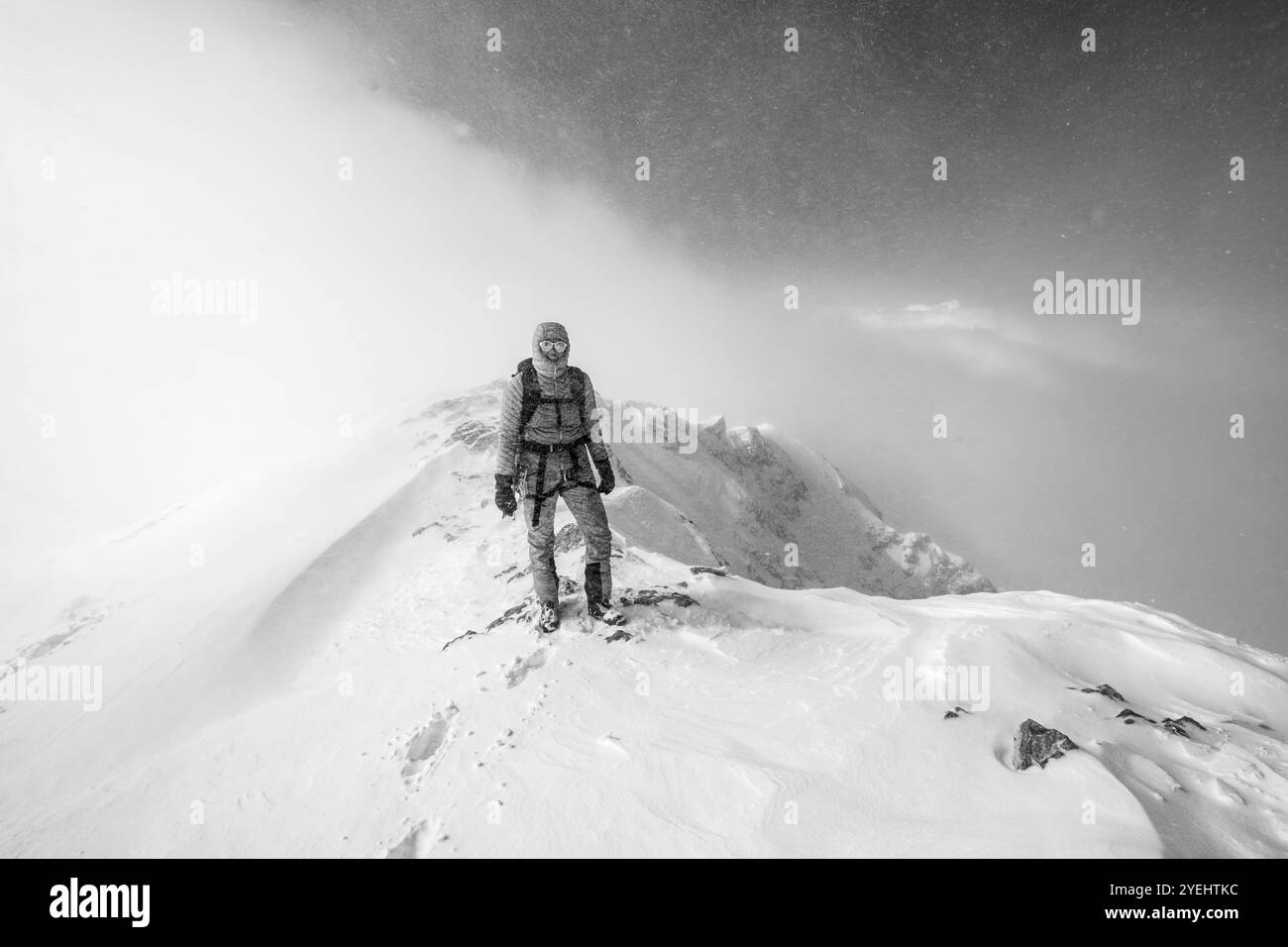 Ski tourer in snowy mountain landscape, at the summit of the Wildhorn, cloudy mood, high tour, black and white photo, Bernese Alps, Bernese Oberland, Stock Photo