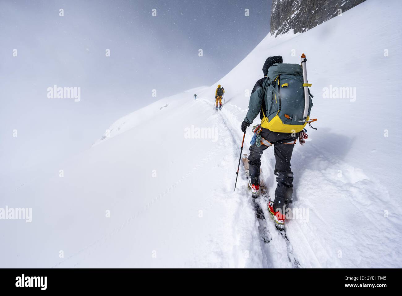 Three ski tourers in a snowy mountain landscape, ascent to the Wildhorn, cloudy mood, high tour, Bernese Alps, Bernese Oberland, Switzerland, Europe Stock Photo