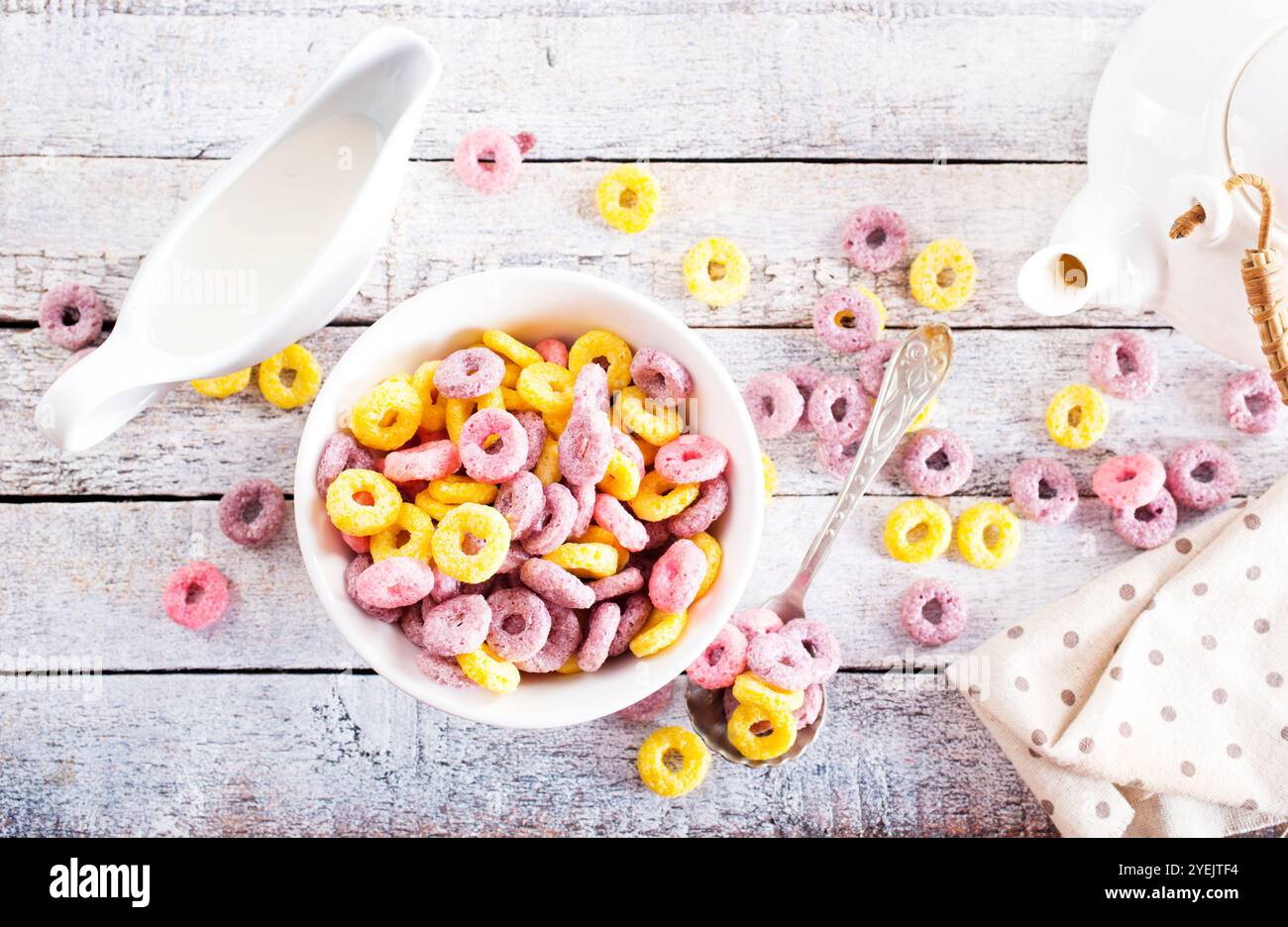 Falling colorful corn rings in bowl on white table Stock Photo