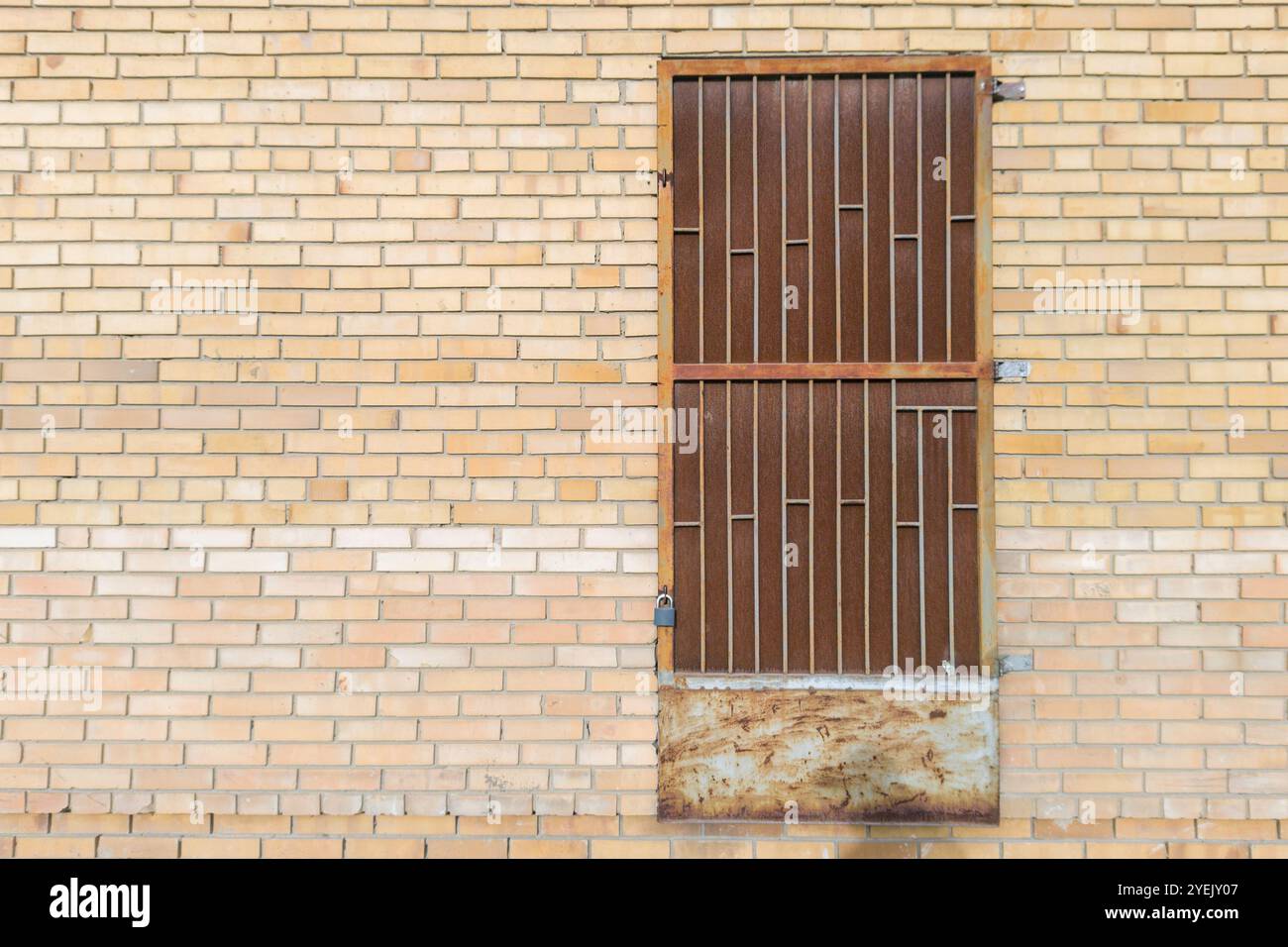 Brick Wall with Rusty Metal Door and Padlock Stock Photo