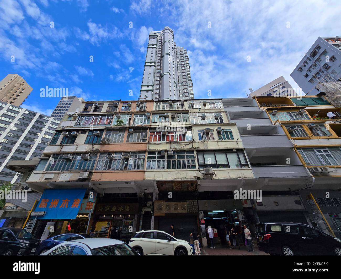 Old residential buildings on Shangha street with a modern residential tower behind them. Mong Kok, Kowloon, Hong Kong. - Smartphone Captured Stock Image