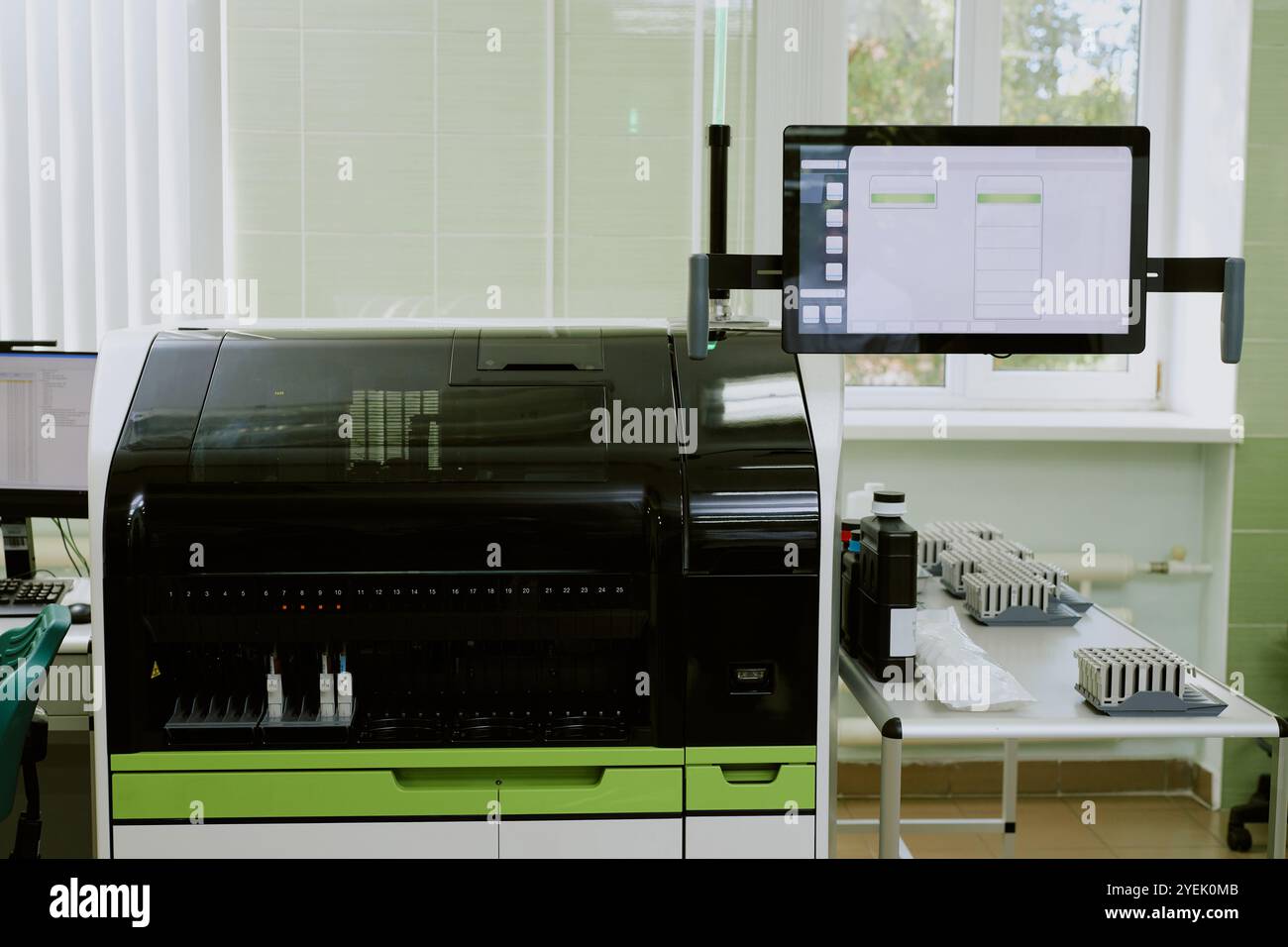 Advanced laboratory setup featuring high-tech machinery and modern gadgets situated next to a window, displaying data on a screen, and arranged for scientific analysis Stock Photo