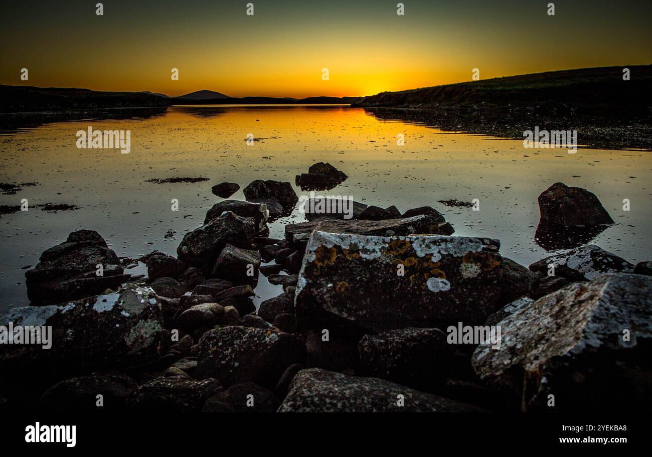 Sun setting over very calm sea Loch Stock Photo