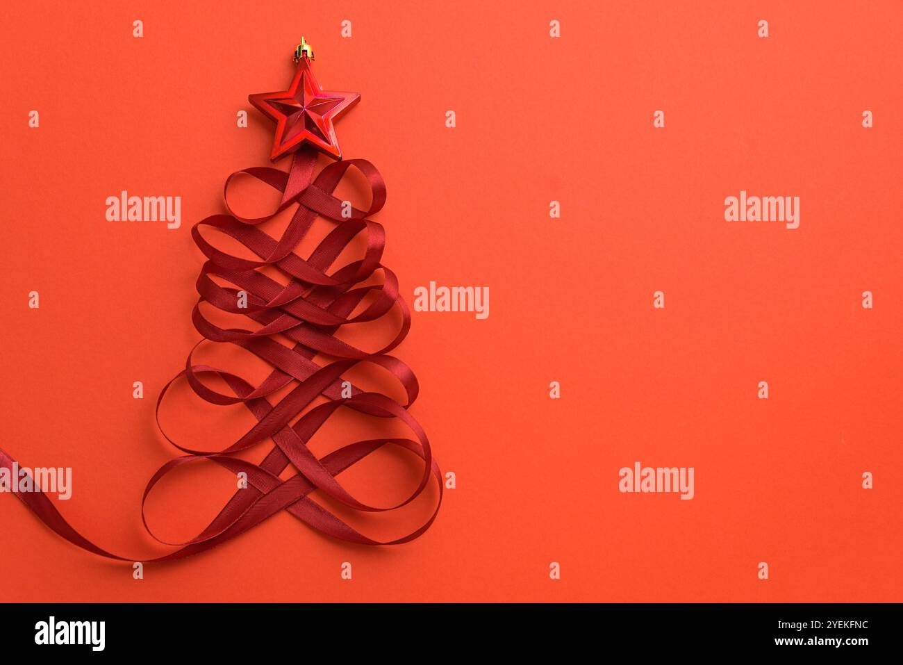 Christmas tree made of red ribbon and star shape toy on red background ...