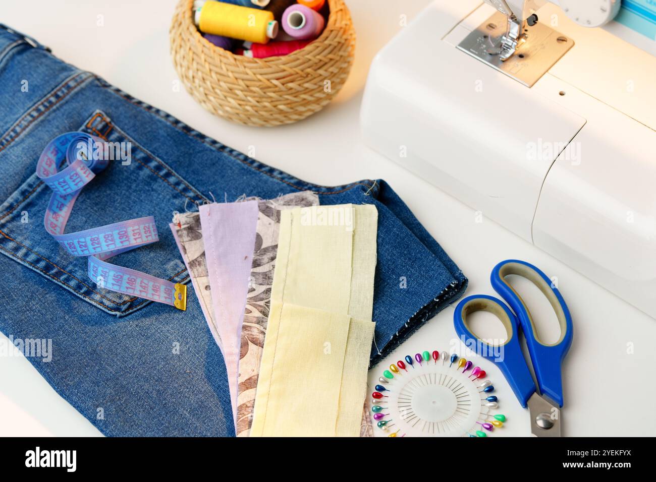A sewing setup featuring a sewing machine, colorful threads, and denim ...