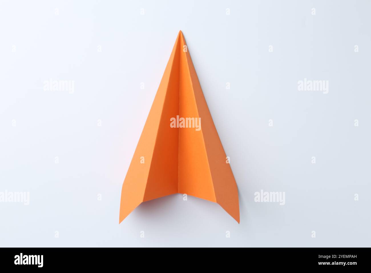 One handmade orange paper plane on white background, top view Stock Photo