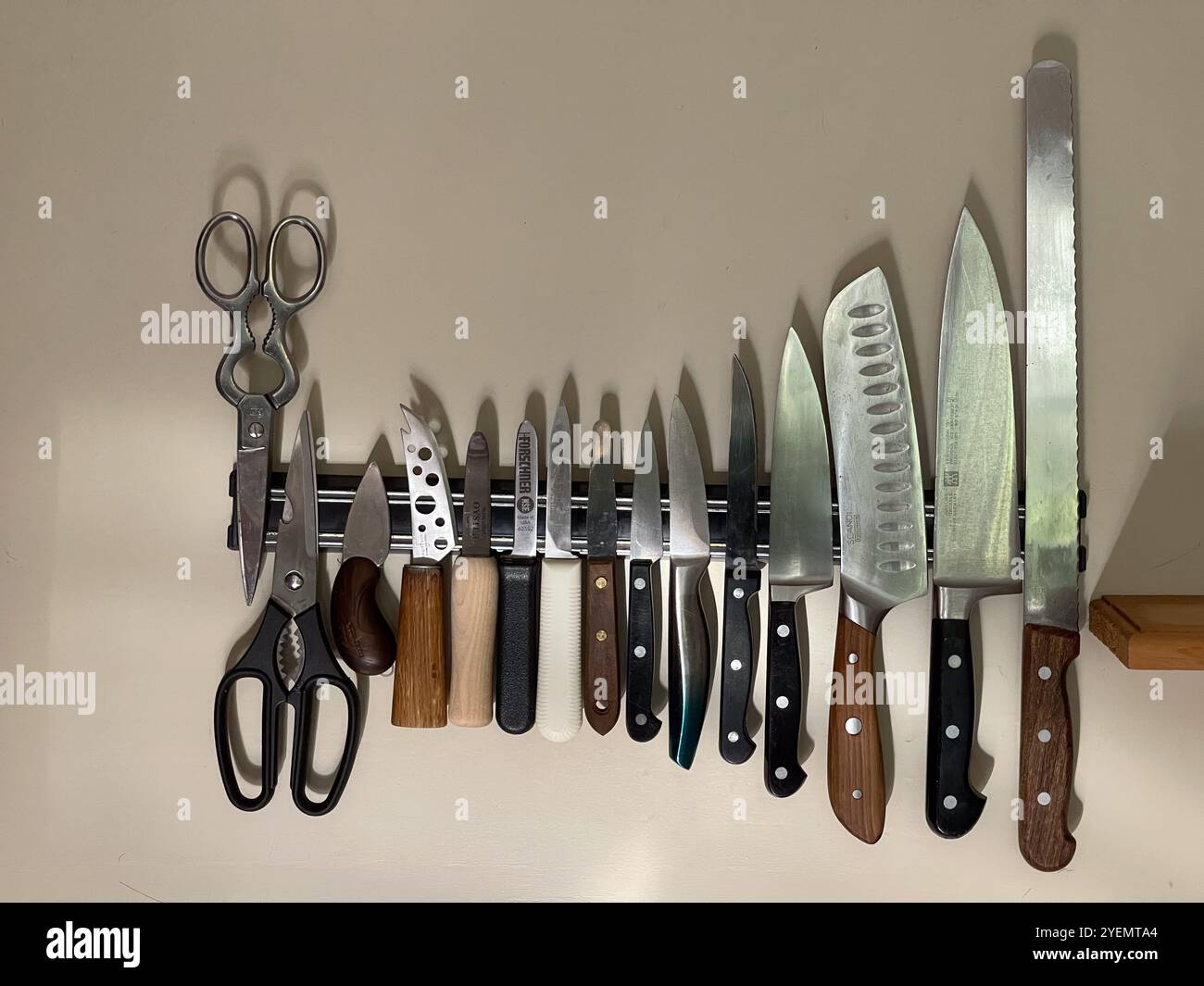 KItchen knives in a row on a magnetic holder in the wall - Smartphone Captured Stock Image