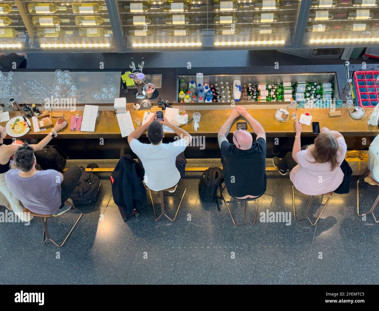 High angle view of people seating in a restaurant bar eating while waiting for their flight connection at the airport, Zurich, Switzerland - Smartphone Captured Stock Image