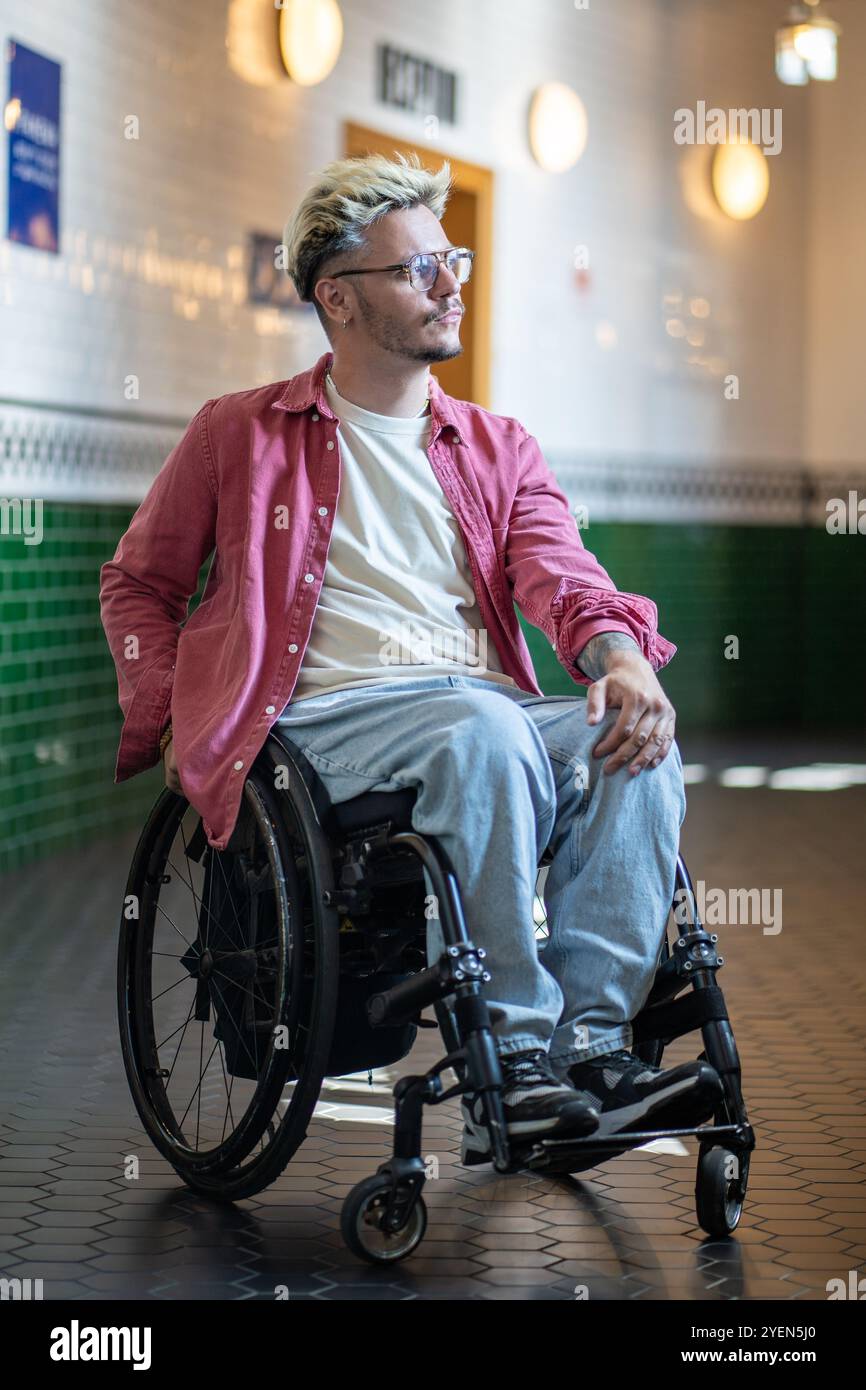 Disability Man Man with disability in wheelchair in public hall, thoughtfully looking ...
