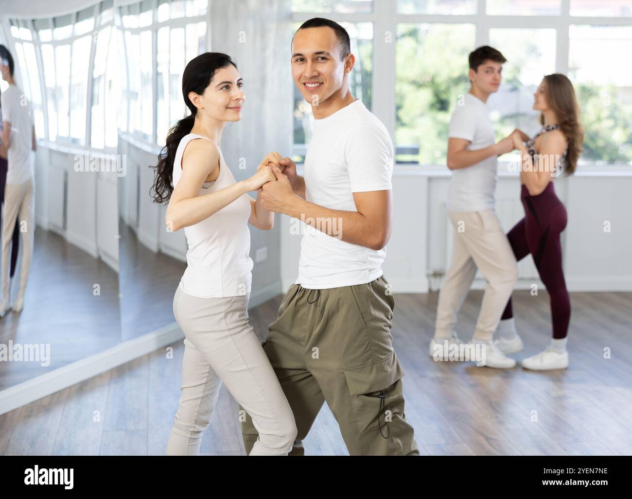 Girl paired up with young man, they train to perform slow waltz dance ...