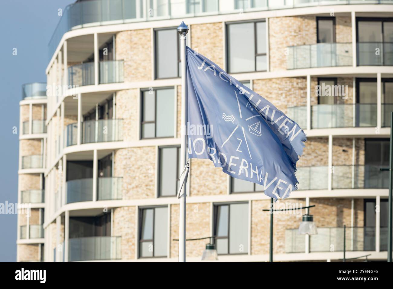 Waving recreational port flag at river IJssel with newly build high ...