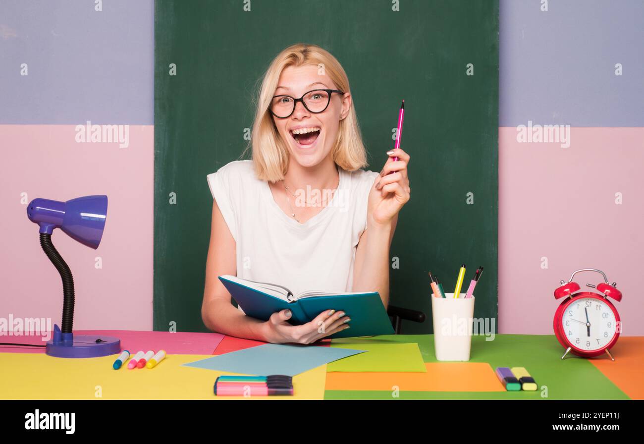 Female teacher at her desk marking students work. Pretty teacher ...