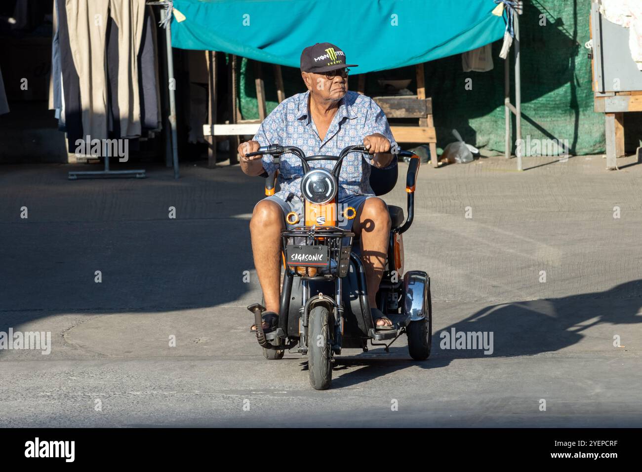 SAMUT PRAKAN, THAILAND, FEB 08 2023, An elderly man rides an electric tricycle Stock Photo