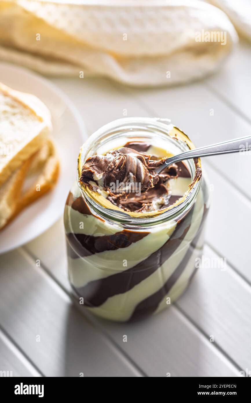 Chocolate cream spread on spoon in a jar. Stock Photo