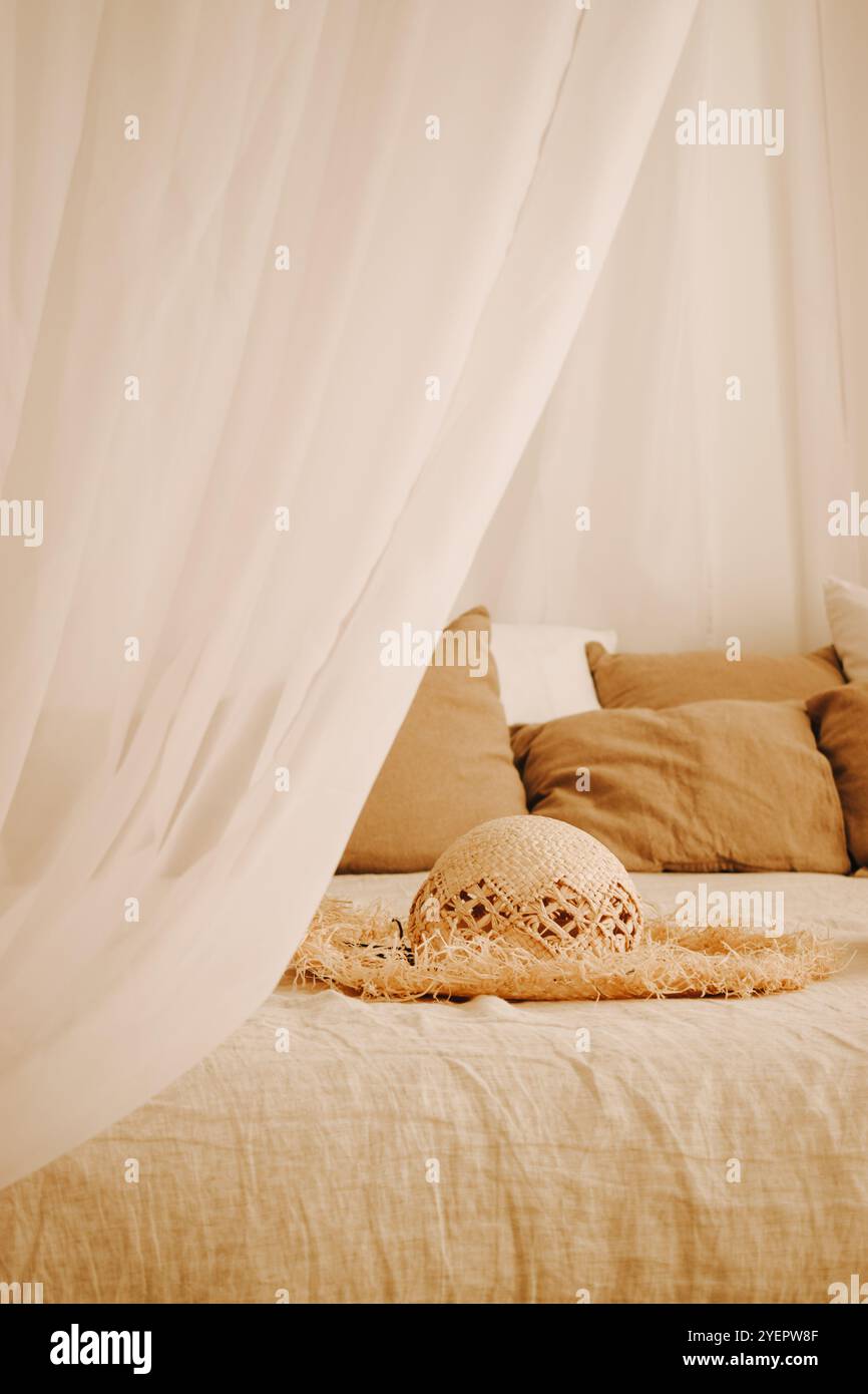a straw hat is lying on the bed Stock Photo