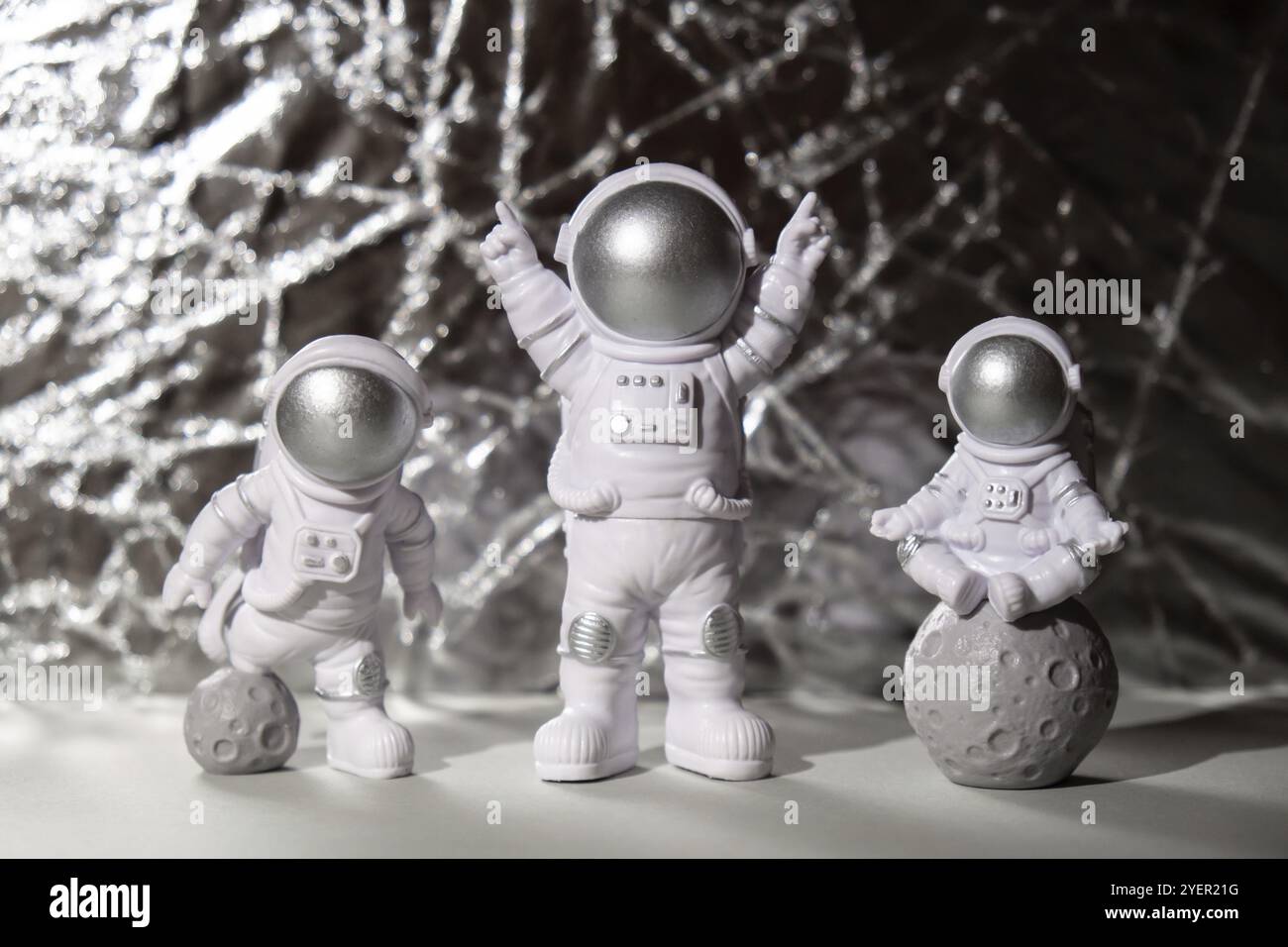 Three Plastic toys figure astronaut on silver background Copy space. Concept of out of earth travel, private spaceman commercial flights. Space missio Stock Photo