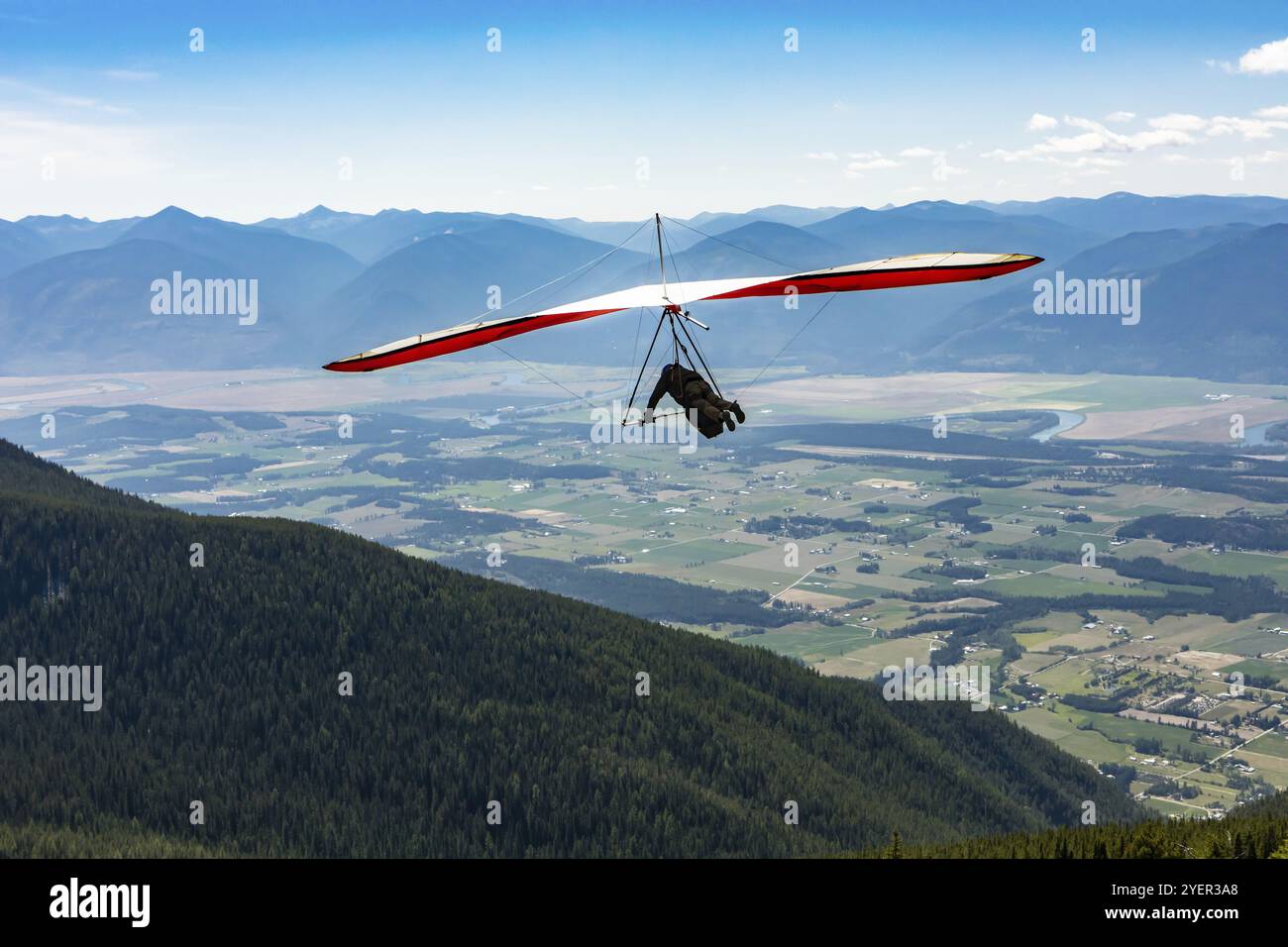 Long shot of flying extremal hang glider. Young man enjoying his recreational journey to Creston, British Columbia, Canada, North America Stock Photo
