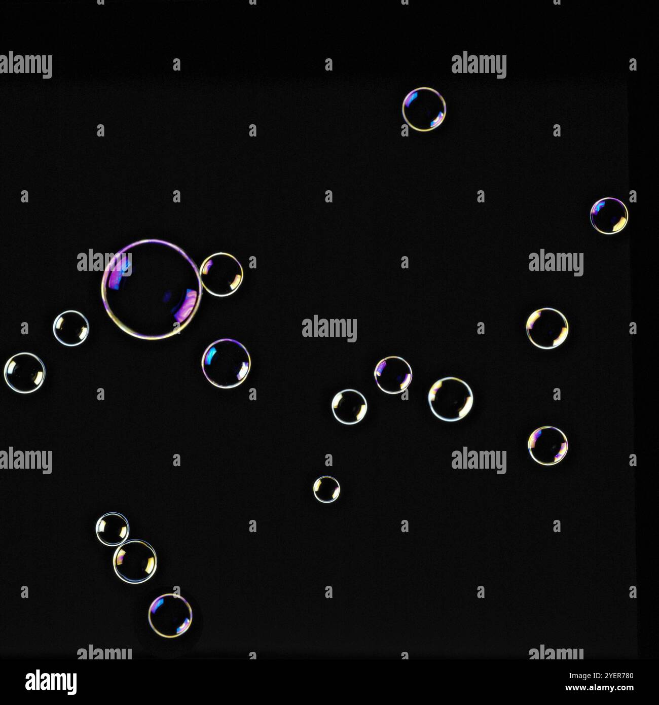 Soap bubbles floating in seven shining colours in black background ...