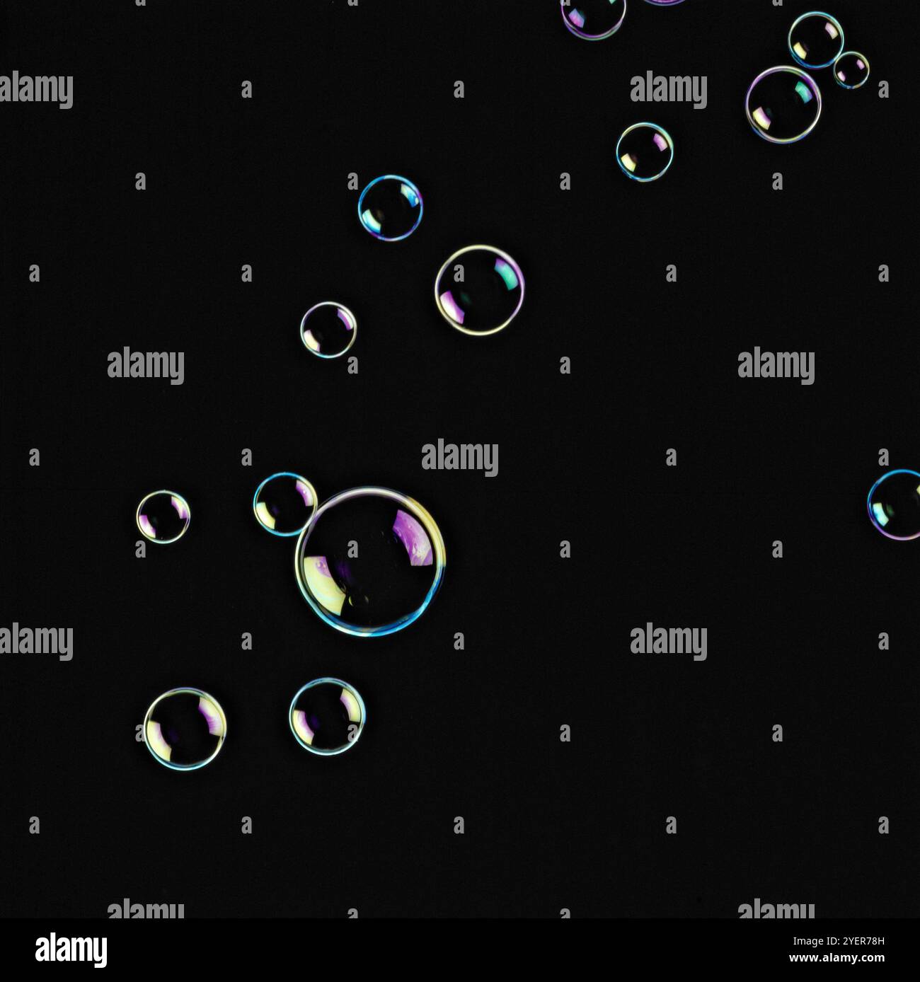 Soap bubbles floating in seven shining colours in black background ...