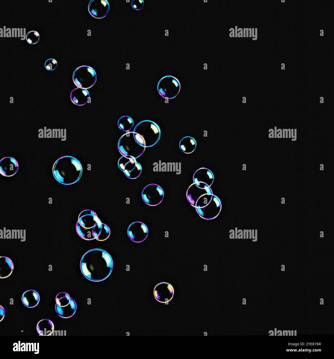 Soap bubbles floating in seven shining colours in black background ...