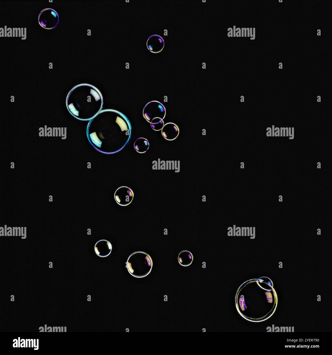 Soap bubbles floating in seven shining colours in black background ...