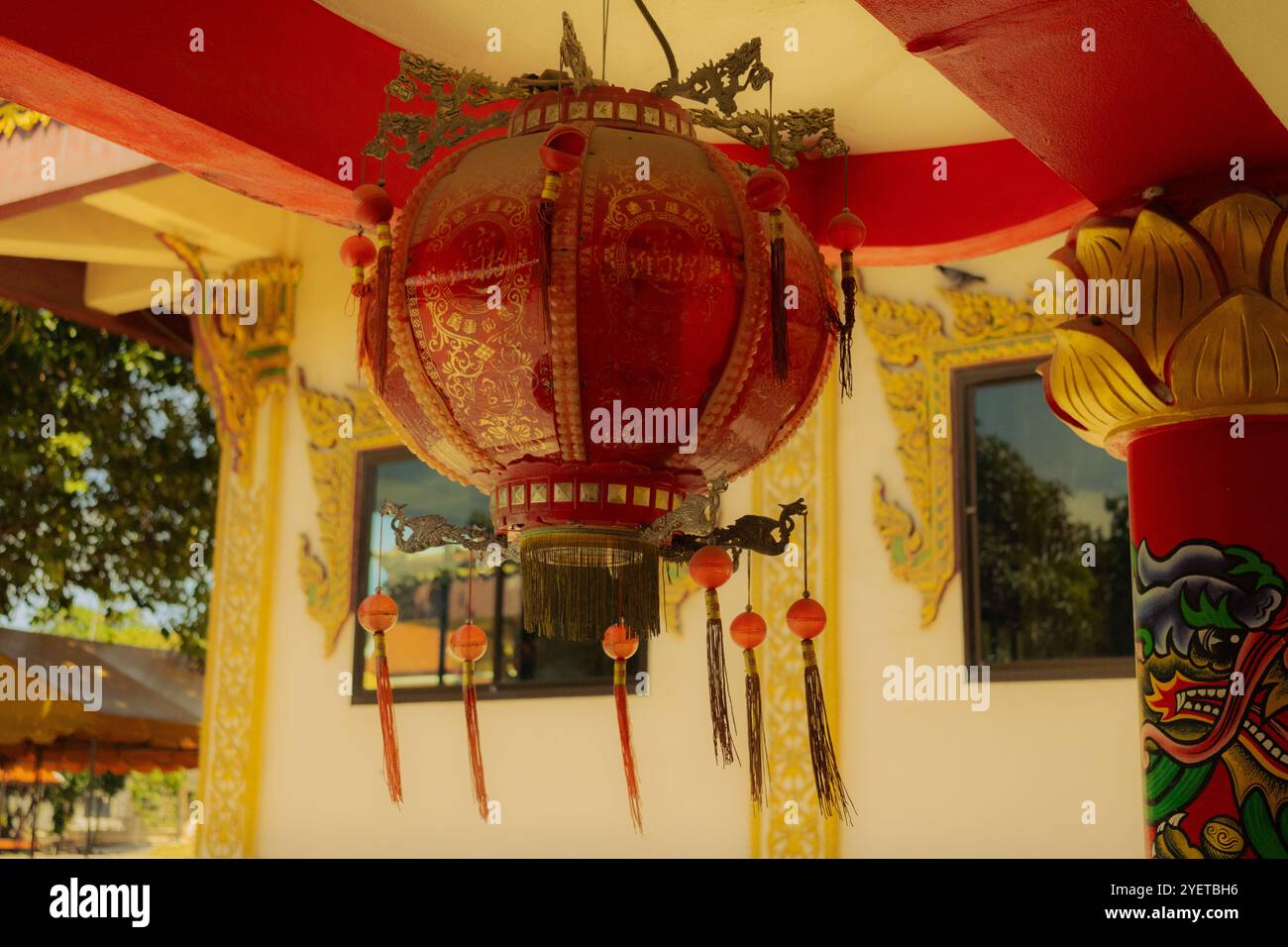 The photo shows a traditional red Chinese lantern with golden patterns ...