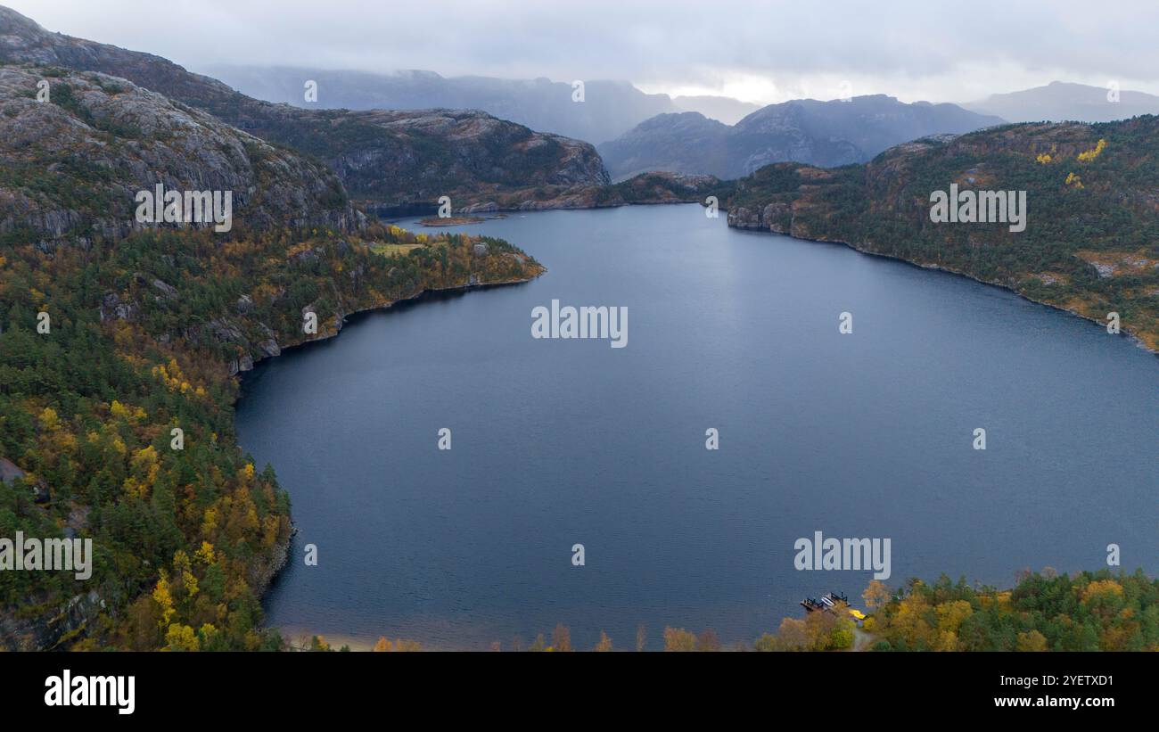 Aerial view of a serene lake surrounded by rugged mountains and autumn ...