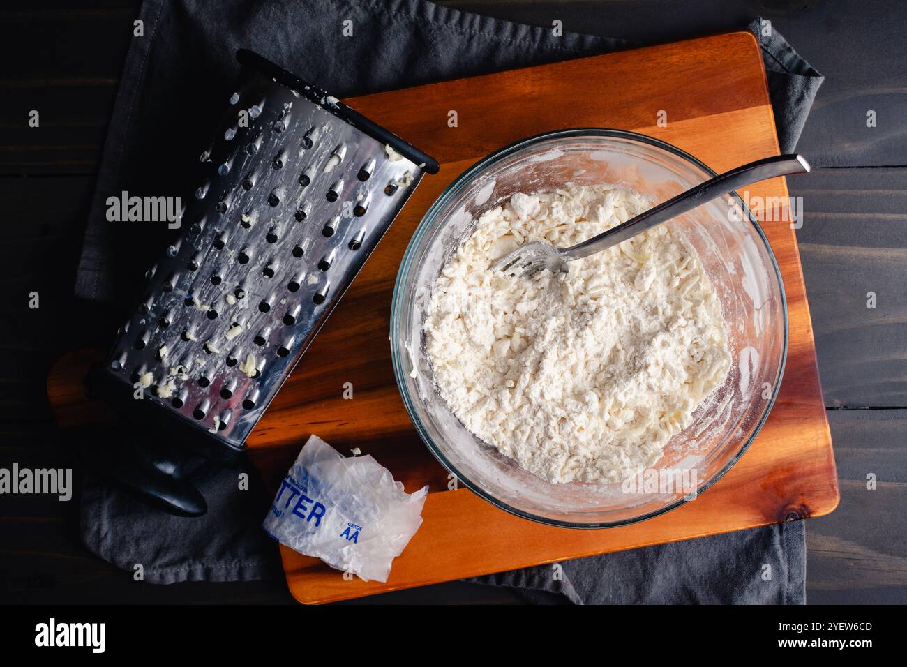 Grated Butter Mixed into Dry Ingredients for Pie Crust: Frozen butter shredded into flour and dry ingredients for homemade pie dough Stock Photo