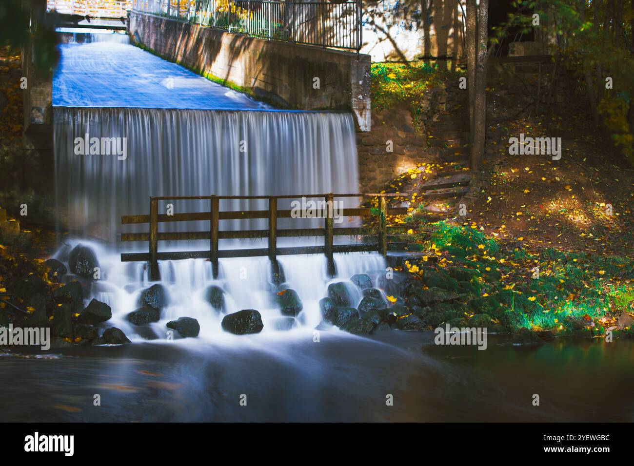 Long exposura image of waterfall in the park of Smiltene city, Latvia. There is a bridge under the waterfall. Stock Photo