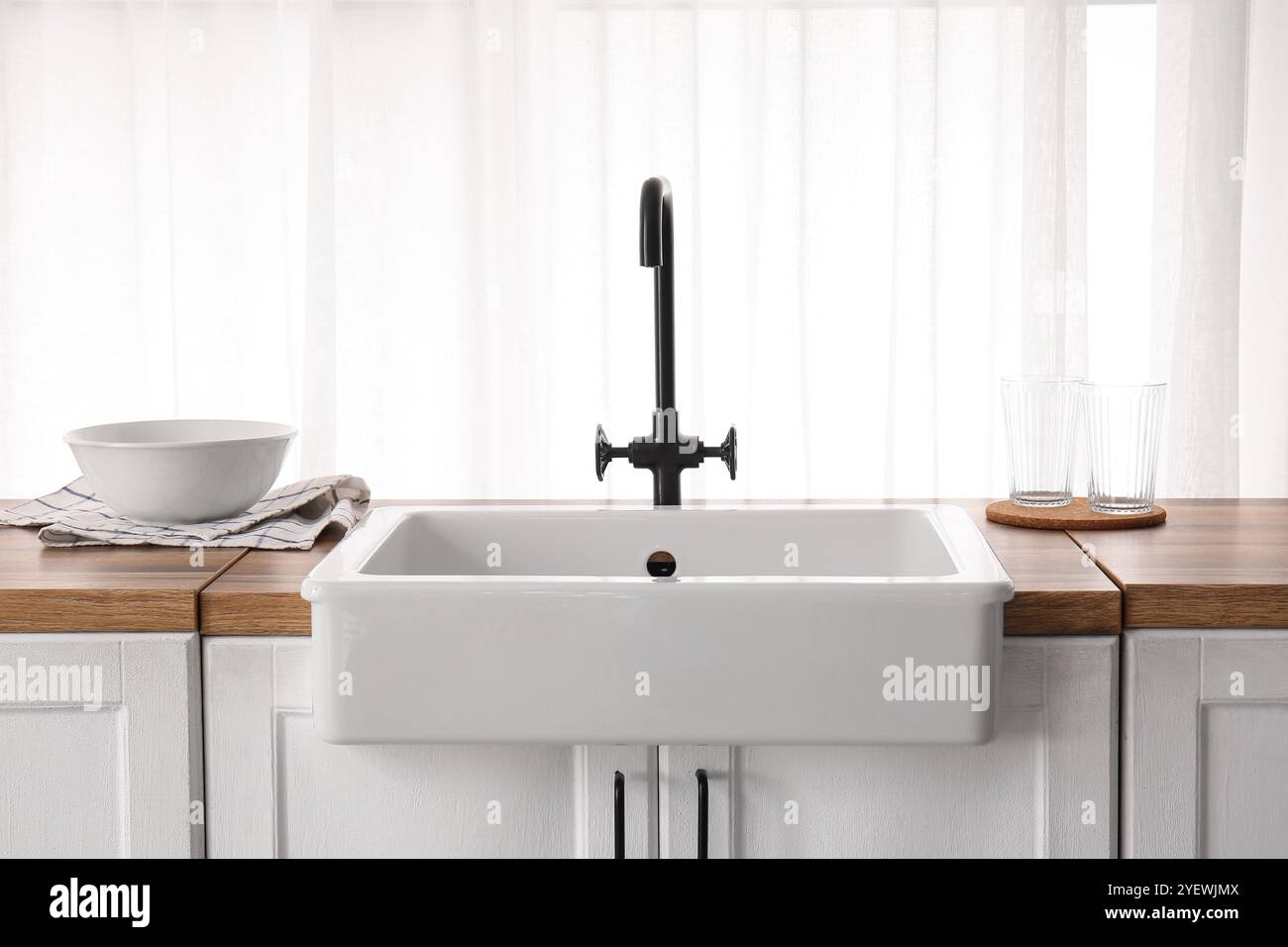 Sink on wooden counter near window in stylish kitchen Stock Photo - Alamy
