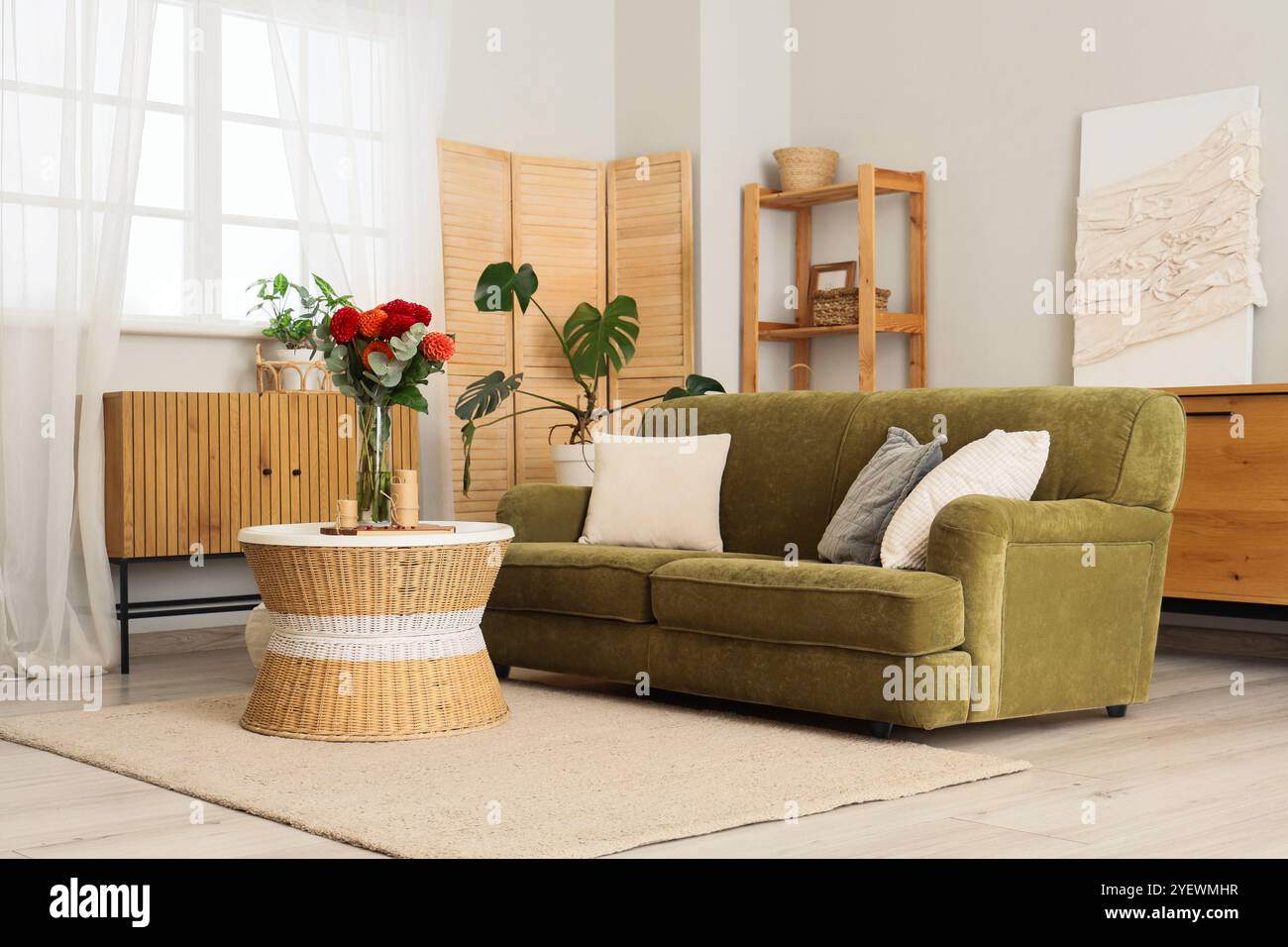 Sofa and dahlia flowers on coffee table in interior of living room ...