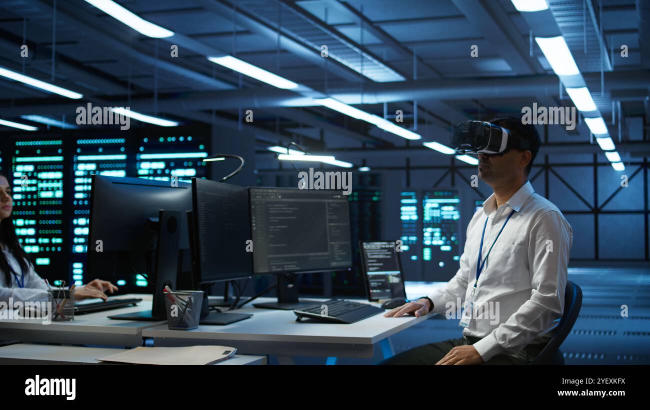Engineer wearing VR headset in data center installing software on computer, troubleshooting issues. IT expert in server hub using virtual reality tech, establishing performance benchmarks, camera B Stock Photo