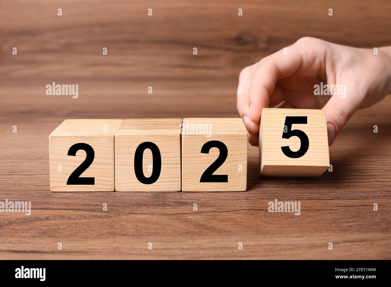 2025 New Year. Woman putting wooden cube with number 5 on table, closeup Stock Photo