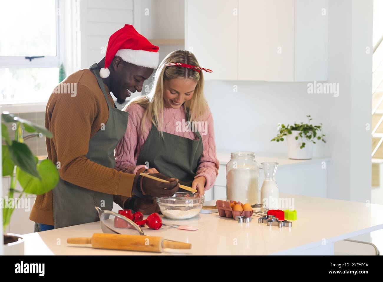 Christmas time, multiracial couple baking, wearing festive holiday attire, at home Stock Photo