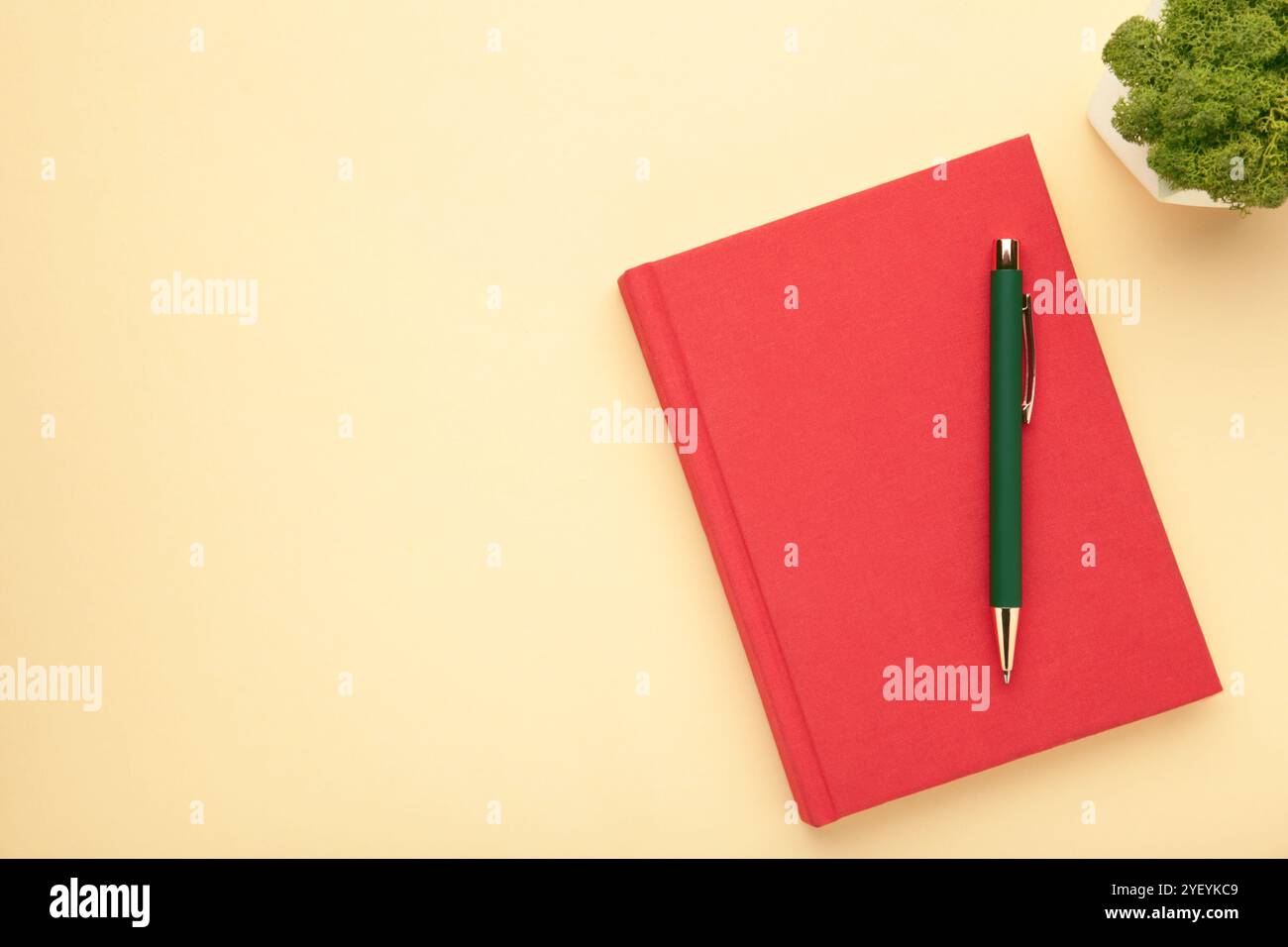 Red notebooks and pen on beige background, top view. Stock Photo