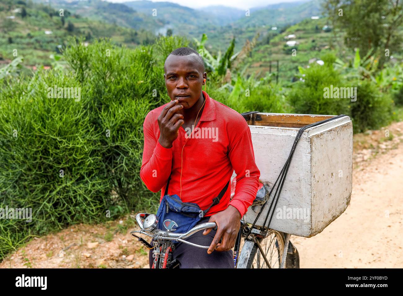 Young man riding a bicycle in western Rwanda. Stock Photo