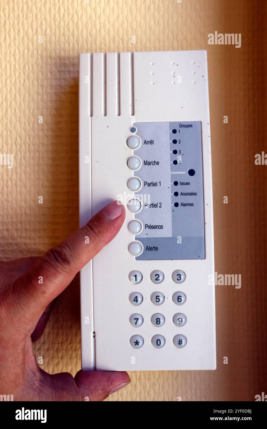 Man Setting Control Panel On Home Security System. France. Stock Photo