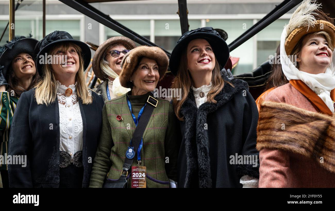 London, UK.  2 November 2024. Women in period costume at a display of veteran cars and more in Pall Mall in the St James’s Motoring Spectacle.  The veteran vehicles will be driven in the RM Sotheby’s London to Brighton Veteran Car Run the following morning, which is being held for the 128th time featuring entrants from around the world.  The event is being hosted by the Royal Automobile Club outside its headquarters.  Credit: Stephen Chung / Alamy Live News Stock Photo