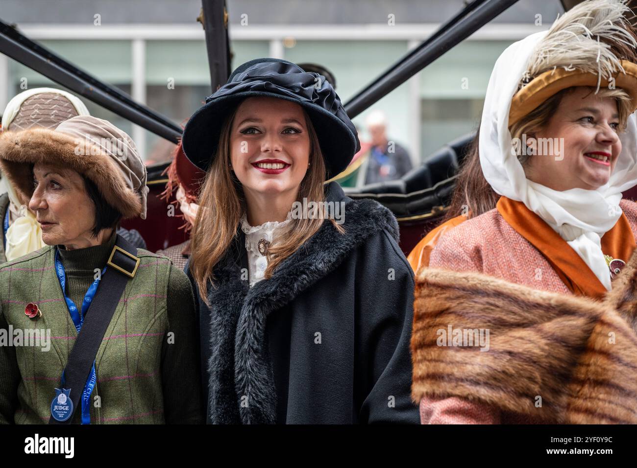 London, UK.  2 November 2024. Women in period costume at a display of veteran cars and more in Pall Mall in the St James’s Motoring Spectacle.  The veteran vehicles will be driven in the RM Sotheby’s London to Brighton Veteran Car Run the following morning, which is being held for the 128th time featuring entrants from around the world.  The event is being hosted by the Royal Automobile Club outside its headquarters.  Credit: Stephen Chung / Alamy Live News Stock Photo